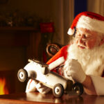 Father Christams painting a toy car in his workshop