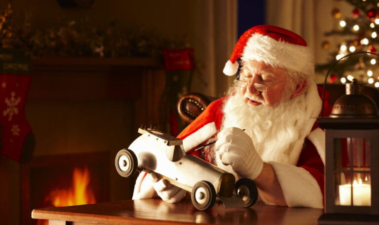 Father Christams painting a toy car in his workshop